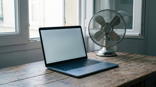 Ordinateur portable sur un bureau près d'une fenêtre ouverte