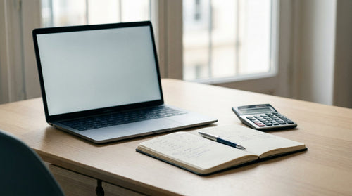 Un ordinateur portable neuf posé sur un bureau avec une calculatrice