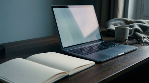Ordinateur portable éclairé par une lampe sur un bureau sombre