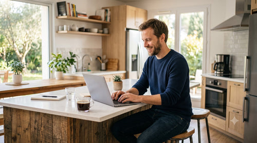 Un homme détendu utilise son PC protégé dans sa cuisine, protection discrète en fond